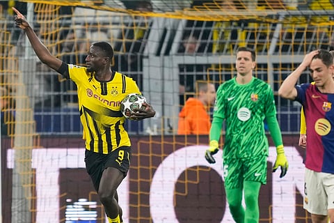 Dortmund's Serhou Guirassy, left, celebrates after scoring the opening goal during the Champions League quarterfinals second leg soccer match between Borussia Dortmund and Barcelona, at the Signa-Iduna Park in Dortmund, Germany, Tuesday, April 15, 2025.