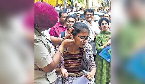A home guard removes earrings of a CET candidate in Bengaluru on Wednesday