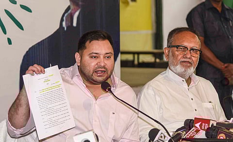 RJD leader Tejashwi Yadav, left, addresses a press conference at the party office, in Patna, Saturday, April 19, 2025.