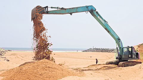 Accumulated sand being removed using an earthmover at the mouth of Muthalapozhi Harbour in Perumathura, Thiruvananthapuram, on Monday