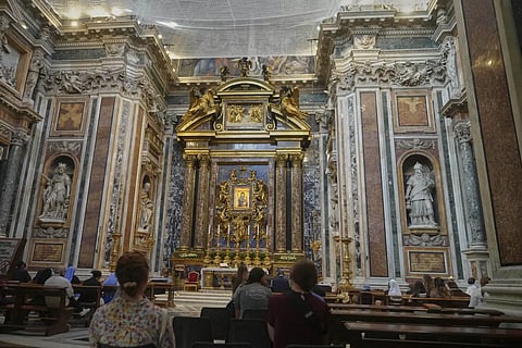 Faithful pray before the Salus populi Romani (Salvation of the people of Rome), a Byzantine-style painting that features an image of Mary, draped in blue robe, holding the infant Jesus who in turn is holding a jeweled golden book, inside St Mary Major basilica, where Pope Francis will be buried, in Rome, Tuesday, April 22, 2025.