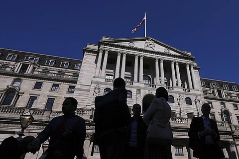 People are silhouetted as they pass the Bank of England in London, Thursday, April 3, 2025