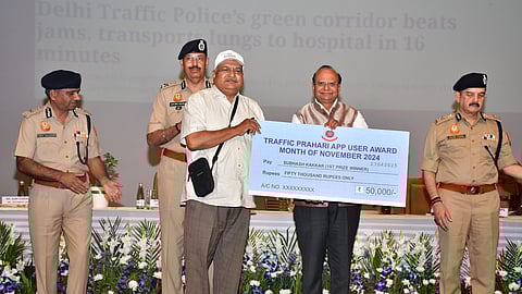Lieutenant Governor VK Saxena presents medals and cash prizes to Traffic Prahari volunteers.