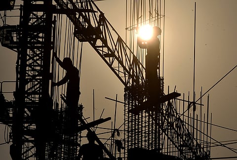 Contruction workers seen like holding sun as they work on a construction site during hot sun today at Bhubaneswar.