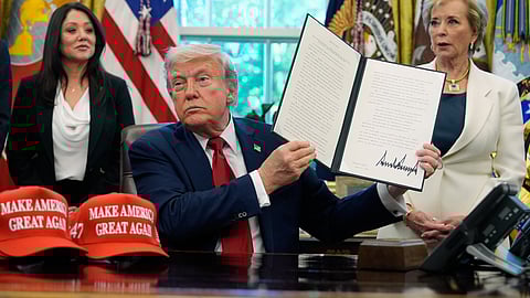 President Donald Trump holds a signed executive order relating to Historically Black Colleges and Universities in the Oval Office of the White House, Wednesday, April 23, 2025, in Washington