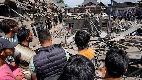 People stand near the house of Ahsan Ul Haq Sheikh, a suspect in the Pahalgam terror attack, which was razed in a blast, in Murran area of Pulwama district, Saturday, April 26, 2025.