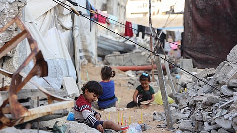 Palestinian children play amid the rubble of destroyed buildings in Gaza City, in the central Gaza Strip on April 26, 2025.
