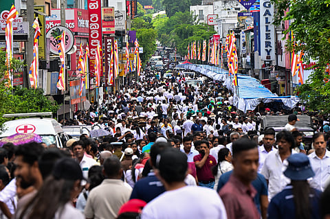 Buddhist devotees stand in queues as they wait to enter the Temple of the Tooth on the final day of public exhibition of the sacred Tooth relic of the Buddha in Kandy on April 27, 2025.