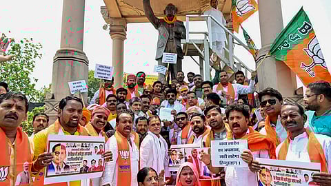 BJP workers stage a protest at Ambedkar Park in Varanasi against the installation of a hoarding featuring BR Ambedkar and Samajwadi Party chief Akhilesh Yadav in half faces (Photo | PTI)