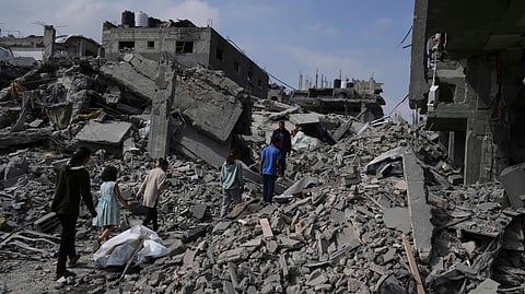 Palestinians walk in the rubbles after an Israeli army airstrike in Beit Lahia, northern Gaza Strip.