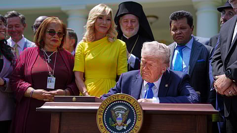 President Donald Trump, surrounded by religious leaders, signs an executive order establishing the Religious Liberty Commission, during a National Day of Prayer event in the Rose Garden of the White House, Thursday, May 1, 2025, in Washington.
