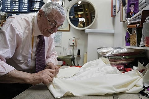 Italian tailor Raniero Mancinelli, who on his own initiative is making outfits for a possible future Pope, works on pontiff's robe inside his shop in Rome, Wednesday, April 30, 2025.