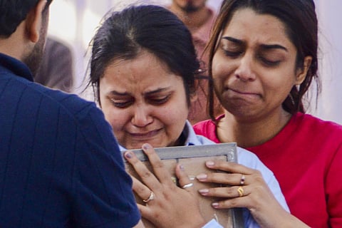 File | Pahalgam terror attack victim Shubham Dwivedi's wife, in blue shirt, and his sister mourn after his mortal remains were brought to his residence, in Kanpur, Thursday, April 24, 2025.