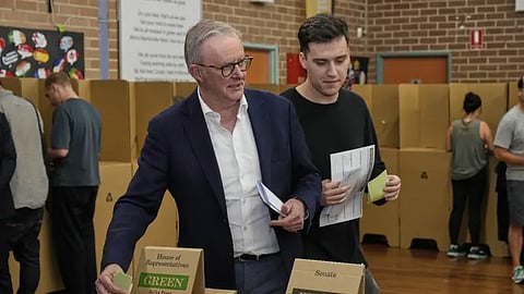 Australian Prime Minister Anthony Albanese and his son Nathan place their votes in a ballot box at a polling booth in his electorate in Sydney, Saturday, May 3, 2025.