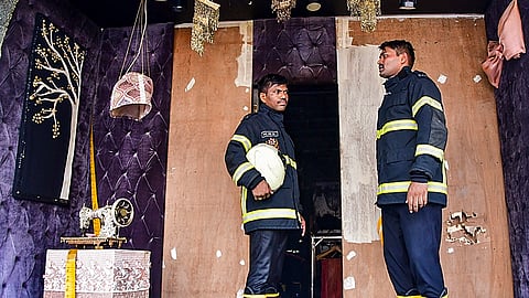 Firefighting team outside a showroom where a fire broke out, near the Nana Chowk in Mumbai, Monday