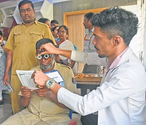 A BMTC staffer gets his eye checked at the free screening camp in Bengaluru on Tuesday | Vinod kumar T