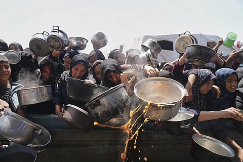 Palestinians struggle to get donated food at a community kitchen in Khan Younis , Gaza Strip, Monday, May 5, 2025.