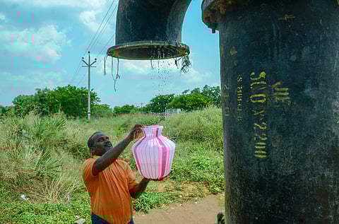 Amid the scorching heat of summer, a man quenches his thirst by collecting water dripping from a leaking drinking water pipeline in Pattanam Panchayat, Coimbatore.