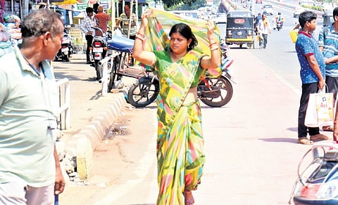A woman uses her saree for protection from the blistering heat