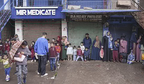 People wait to leave for safe places following shelling by Pakistani troops in Uri in Baramulla district on Friday, May 9, 2025.