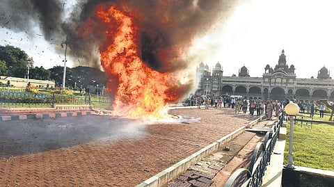A fire rages on the Mysuru Palace grounds (left), as part of a civil defence mock drill under ‘Operation Abhyas’, as security personnel keep vigil on Saturday