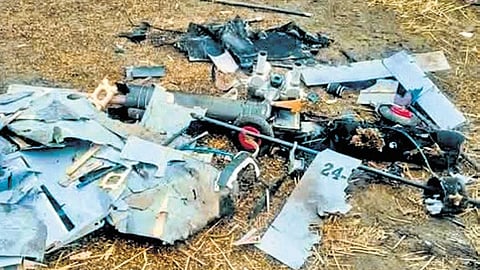 People gather near a suspicious object resembling remains of a drone in Kangra district of HP.