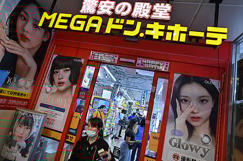 This photo taken on April 21, 2025 shows a woman leaving a branch of Japanese discount retailer Don Quijote, also known overseas as Don Don Donki, in the Shibuya district of central Tokyo.