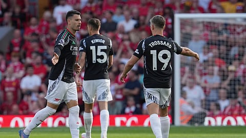 Arsenal's Gabriel Martinelli, left, celebrates with teammates after scoring his side's opening goal during the English Premier League soccer match between Liverpool and Arsenal, at Anfield stadium in Liverpool, England, Sunday, May 11, 2025.