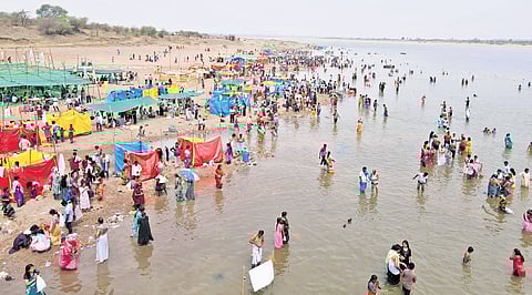 Devotees take a dip at the confluence of the Godavari, Pranahita and Saraswati rivers on the second day of Saraswati Pushkaralu in Kaleshwaram on Friday