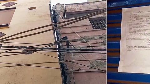 Municipal Corporation of Delhi (MCD) officials paste a notice on a building that has tilted to one side, at Bihari Colony, Shahdara, in New Delhi on Friday.