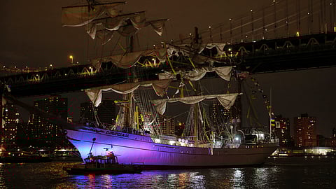 A New York Police Department harbor unit passes in front of the Cuauhtémoc, a masted Mexican Navy training ship as it sits stranded near the Manhattan Bridge after colliding with the Brooklyn Bridge, Saturday, May 17, 2025, in New York.