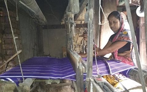 A woman busy with weaving work