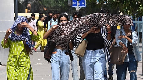 Commuters brave the heat wave during a hot summer afternoon at Sarojini Nagar Market as the temperature rises, on May 18, 2025 in New Delhi.