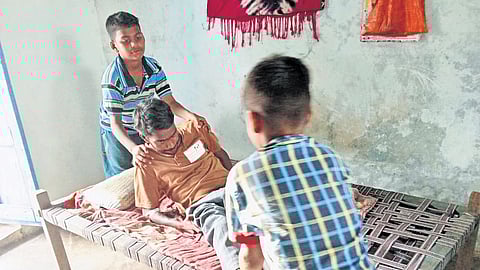 M Satish, the dialysis patient, is helped out of bed by his two sons on Monday