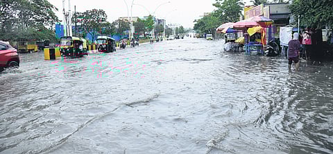 Vehicles wade through a waterlogged road in Davangere
