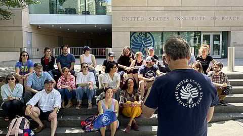 US Institute of Peace employees hold an impromptu celebration on the steps of the US Institute of Peace, Monday, May 19, 2025, in Washington, after a federal district judge blocked the Trump administration from moving forward with dismantling the organisation.