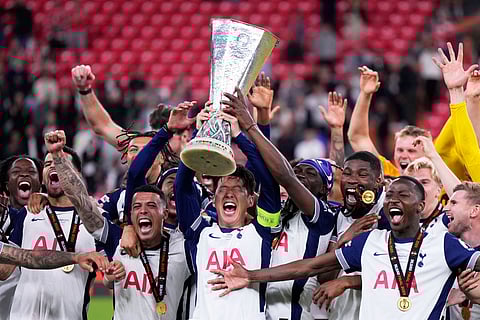 Tottenham's Son Heung-min holds the trophy aloft as he celebrates with teammates after winning the Europa League final soccer match against Manchester United at the San Mames Stadium in Bilbao, Spain, Wednesday, May 21, 2025.