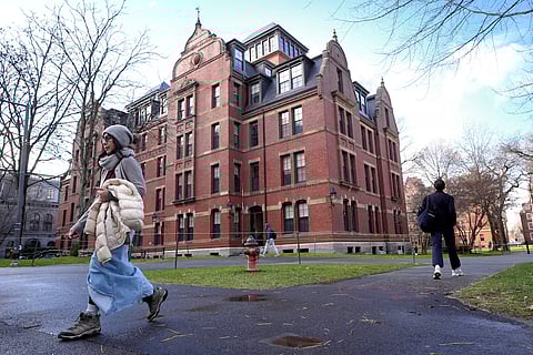 People walk between buildings, Dec. 17, 2024, on the campus of Harvard University in Cambridge, Mass.