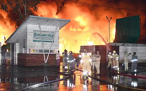 Firemen douse a fire at a factory at the Ujhani area, in Budaun district, Uttar Pradesh, late Wednesday, May 21, 2025.