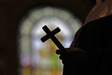 A silhouette of a crucifix and a stained glass window is seen inside a Catholic Church in New Orleans, Dec. 1, 2012.