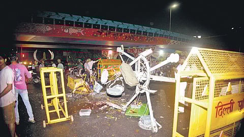 People stand near a collapsed electricity pole