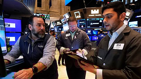 Specialist Michael Pistillo, left, works with traders Ryan Falvey, center, and Niall Pawa on the floor of the New York Stock Exchange, Friday.