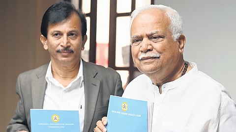 Congress MLA RV Deshpande poses with the report of the Karnataka Administrative Reforms Commission- II, in Bengaluru on Thursday