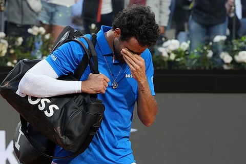Italy's Matteo Berrettini walks off the court following an injury during his tennis match against Norway's Casper Ruud.