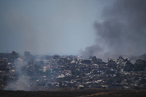 Smoke rises amid buildings that were destroyed during the Israeli ground and air operations in northern of Gaza Strip as seen from southern Israel, Friday, May 23, 2025.