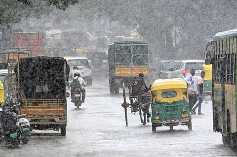 Vehicles wade during a Rain in Bengaluru city near corporation on Friday.