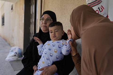 Palestinian Hazar Estity kisses her 21-month-old son, Nizar, who is being held by his grandmother, Nazek, on April 29, 2025, at an apartment in the West Bank town of Zababdeh. Estity says she was used as a human shield by Israeli soldiers.