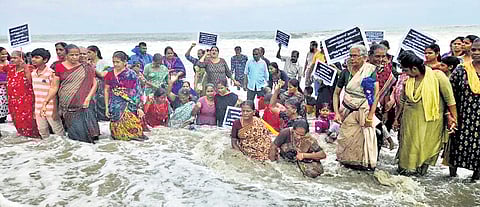 Residents of Kannamaly, Saudi and Manassery stand in knee-deep water in the sea demanding steps to protect the coastal hamlets on Saturday