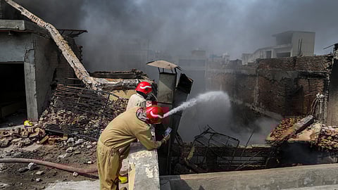Firefighters try to douse a fire that broke out at a factory, at Bawana industrial area, in New Delhi, Saturday, May 24, 2025. The fire triggered an explosion, causing the building to collapse