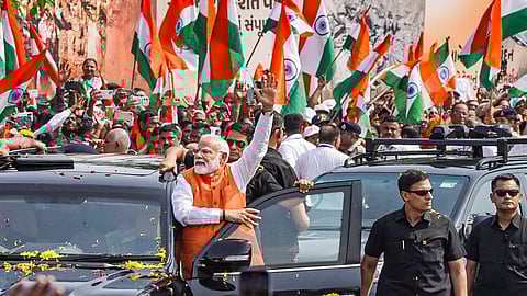 Prime Minister Narendra Modi waves at supporters during a roadshow in Vadodara, Gujarat.